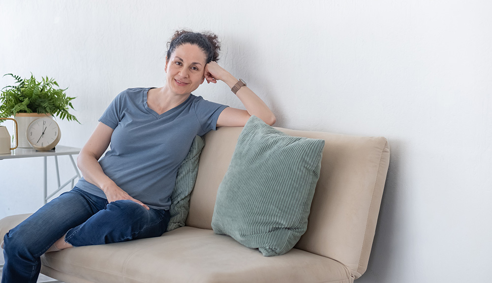 Nil sitting on a couch and smiling.